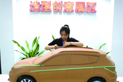 科技创新展现场，工作人员正在进行油泥秀模型制作展示