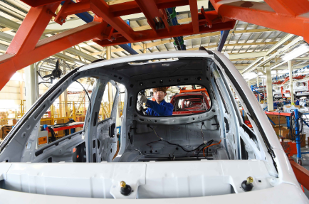 工人在汽车生产流水线上进行检测。 视觉中国